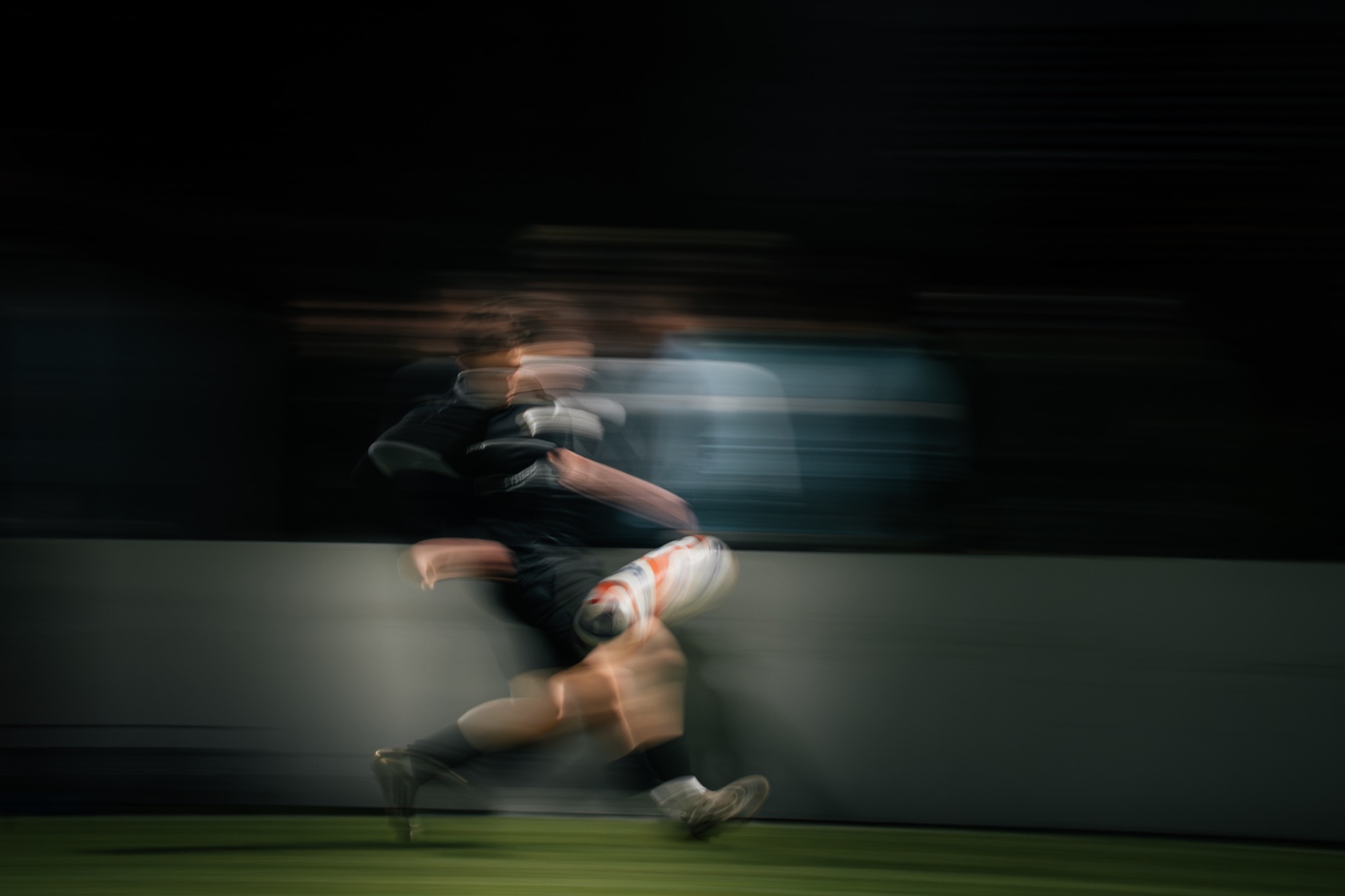 Fußballspieler in Bewegung unter Flutlicht