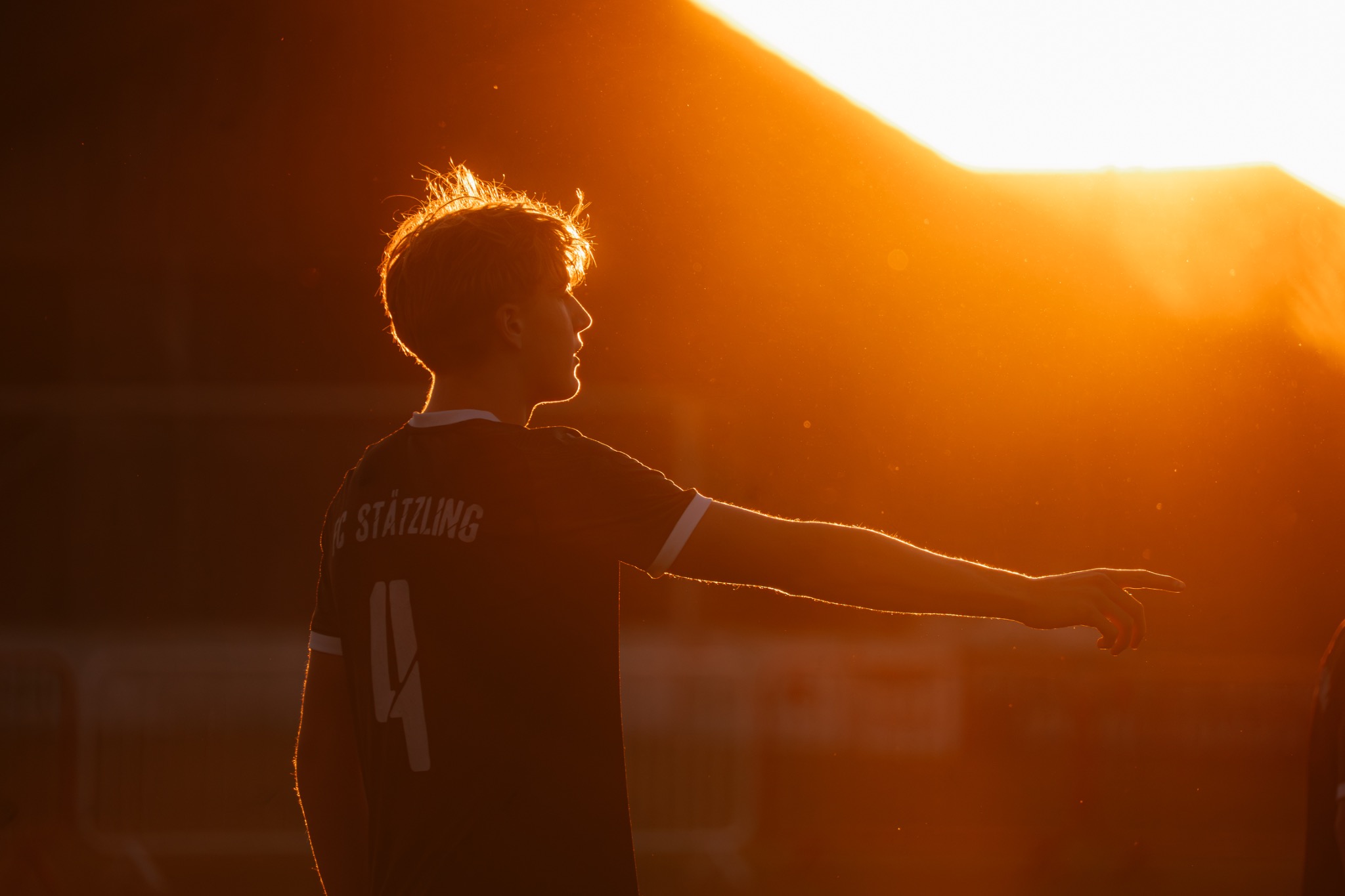 Fußballspieler im Gegenlicht der untergehenden Sonne